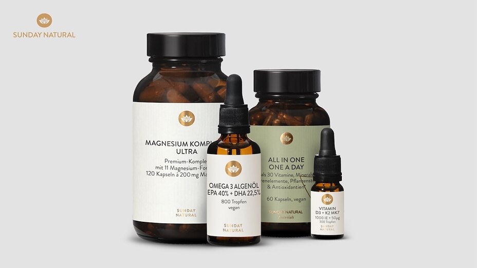 Vier Sunday Natural Produkte, darunter Magnesium Komplex Ultra, Omega 3 Algenöl und Vitamin D3 + K2 Öl, auf neutralem hellgrauem Hintergrund.