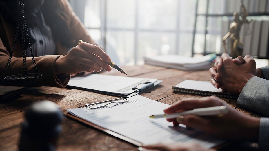 Beratungsgespräch bei einem Anwalt über rechtliche Vereinbarungen und Dokumente.