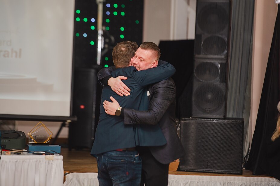 Inhaber von MySolarExpress umarmt einen Vertriebsmitarbeiter als Zeichen der Anerkennung für eine herausragende Leistung