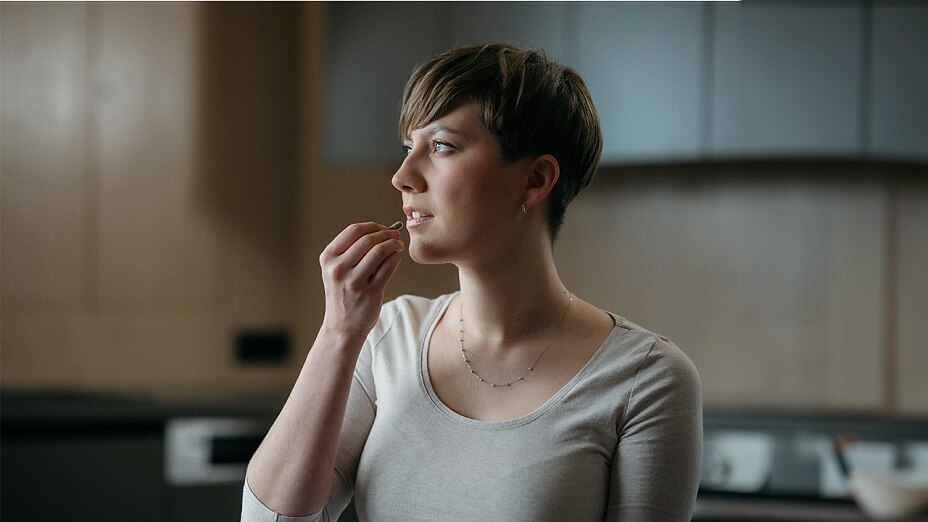 Frau nimmt Mikronährstoffe-Kapsel ein