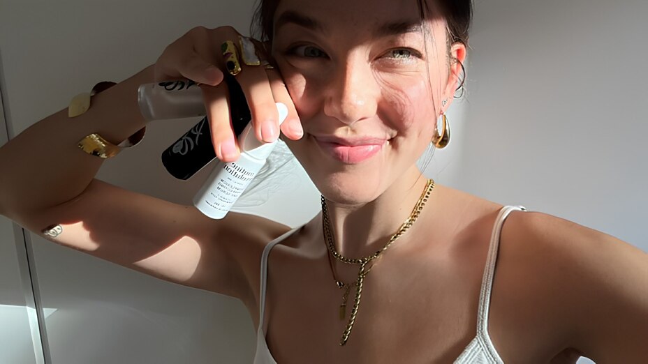 Paula im hellen Bad hält ihre Routine-Revolution-Produkten in die Kamera – natürliches Licht, Produkte in der Hand
